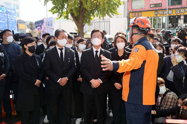 이재명 더불어민주당 대표가 31일 오전 서울 용산구 이태원 압사 참사 현장을 방문, 최성범 용산소방서장으로부터 브리핑을 받으며 사고에 관해 질문하고 있다. [연합]