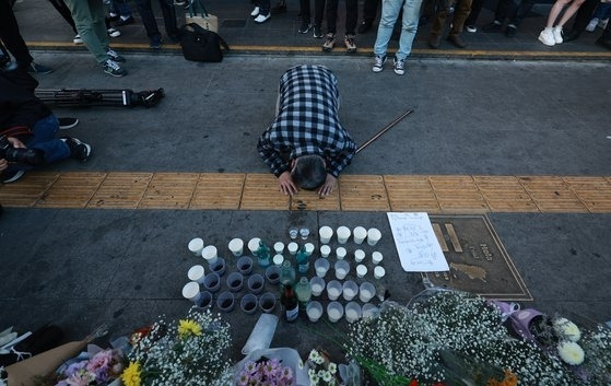 30일 오후 서울 용산구 지하철 6호선 이태원역 1번 출구 앞에 마련된 참사 희생자 추모 공간에서 한 시민이 절을 하고 있다. 연합뉴스