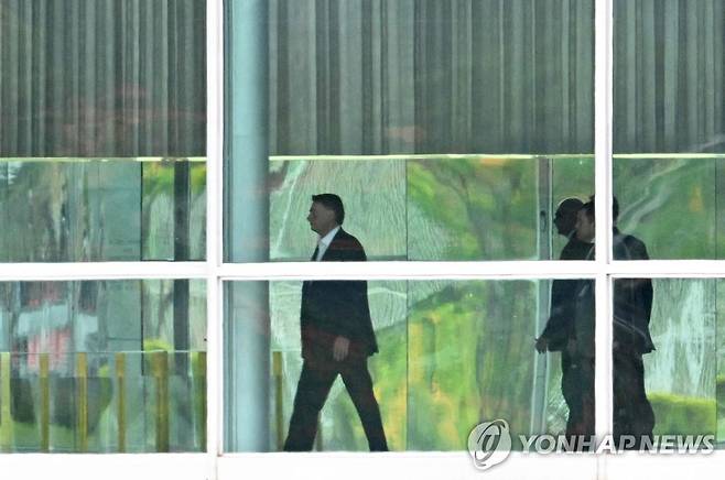 집무실로 이동하는 보우소나루 대통령 (브라질리아 AFP=연합뉴스) 연임을 노린 대선에서 패배한 자이르 보우소나루 브라질 대통령(가운데)이 선거일 이튿날인 31일(현지시간) 브라질리아 대통령궁 안에서 집무실로 이동하고 있다. 2022.10.31