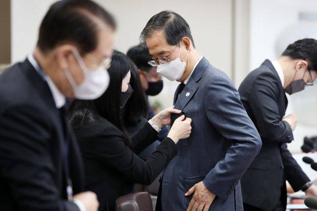 한덕수 국무총리가  1일 서울 용산 대통령실 청사에서 열린 국무회의에 입장, 기존에 착용한 근조 리본 대신 길이가 짧고 글씨가 없는 검은색 리본으로 바꿔달고 있다. 대통령실통신사진기자단