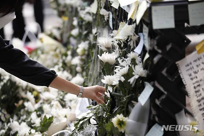[서울=뉴시스] 정병혁 기자 = 1일 오전 서울 용산구 이태원역에 마련된 추모공간을 찾은 시민이 헌화하고 있다. 2022.11.01. jhope@newsis.com