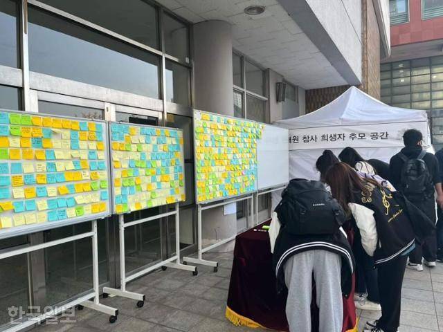 1일 서울 마포구 서강대 체육관 앞에 마련된 이태원 참사 추모 공간에서 학생들이 추모 글귀를 작성하고 있다. 독자 제공