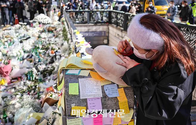 2일 서울 용산구 이태원역 1번 출구에 마련된 이태원 사고 추모공간을 찾은 한 외국인 조문객이 추모 메시지를 남기고 있다. 2022.11.2 [박형기기자]