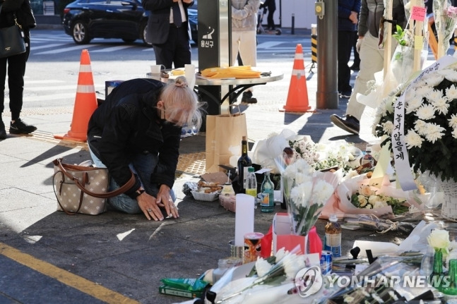 2일 서울 용산구 이태원역 1번 출구 앞에서 한 외국인이 한국식으로 절을 하면서 고인들을 추모하고 있다. <사진=연합>