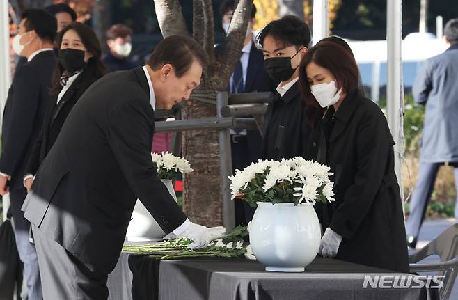 [서울=뉴시스] 전신 기자 = 윤석열 대통령이 2일 서울광장에 마련된 이태원 사고 사망자 합동분향소에서 헌화를 위해 국화꽃을 집어 들고 있다. (대통령실통신사진기자단) 2022.11.02. photo1006@newsis.com