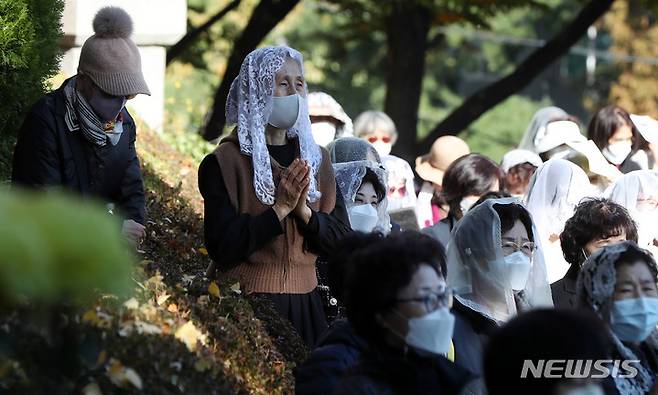 [서울=뉴시스] 추상철 기자 = 2일 오후 서울 용산구 천주교 용산성당에서 열린 '이태원 참사' 희생자를 추모하는 위령의 날 미사에서 참석자가 기도를 하고 있다. 2022.11.02. scchoo@newsis.com