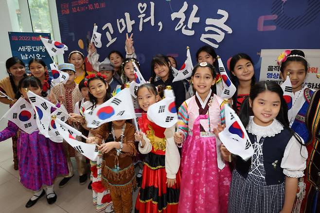 다문화가정 자녀들로 구성된 아름드리합창단원들이 9일 오전 서울 용산구 국립 한글박물관에서 열린 576돌 한글날 경축식에서 축하공연을 펼친 뒤 태극기를 흔들며 기념촬영을 하고 있다. (사진=연합뉴스)