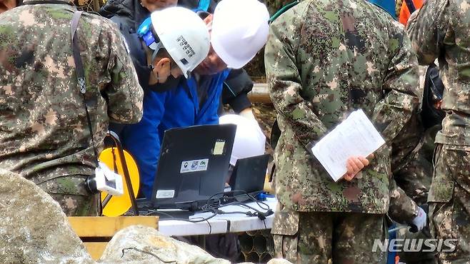 [봉화=뉴시스] 김진호 기자 = 매몰사고가 발생한 경북 봉화군 아연 광산 시추현장에서 3일 구조 당국 관계자들이 내시경 카메라를 통해 갱도 내 상황을 확인하고 있다. 2022.11.03  kjh9326@newsis.com