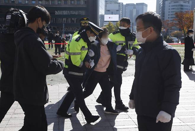 4일 서울광장에 마련된 이태원 사고 희생자 합동분향소에서 한 유족이 윤석열 대통령과 오세훈 서울시장의 근조화환을 내동댕이치고 대통령과 행안부 장관의 사죄를 촉구하며 분노하다 경찰에 의해 끌려 나가고 있다 (사진=뉴시스)