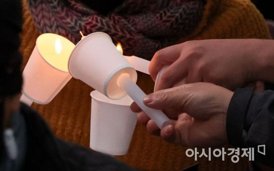 5일 서울광장 인근 도로에서 열린 '이태원 참사 희생자 추모 촛불집회'에서 시민들이 촛불을 나누고 있다./윤동주 기자 doso7@