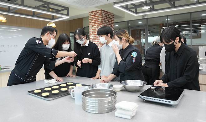 달서고 학생들이 영진전문대 김동인 조리제과제빵과 교수(왼쪽) 지도를 받으며 에그타르트를 만들고 있다. *재판매 및 DB 금지