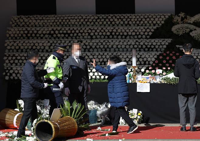 4일 오후 서울 중구 시청 앞 서울광장에 마련된 이태원 참사 희생자 합동 분향소에 이번 참사로 아들을 잃은 한 유족이 당일 부실대응에 윤석열 대통령과 오세훈 서울시장의 근조화환을 쓰러뜨리고 있다. 연합뉴스