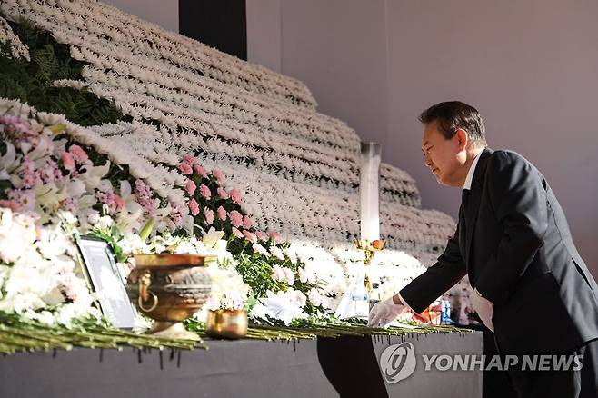 헌화하는 윤석열 대통령 (서울=연합뉴스) 서명곤 기자 = 윤석열 대통령이 5일 오전 서울광장에 마련된 이태원 사고 사망자 합동분향소를 방문, 헌화하고 있다. 2022.11.5 [대통령실 제공, 재판매 및 DB 금지] seephoto@yna.co.kr