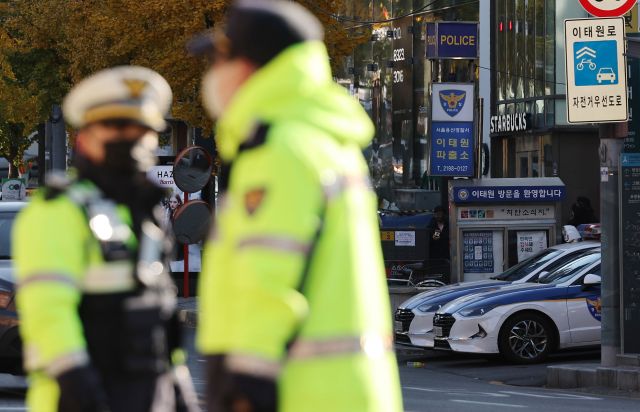 4일 오전 서울 용산구 이태원역 1번 출구 앞 참사 추모 공간에서 보이는 이태원 파출소와 근무 중인 경찰들. 연합뉴스