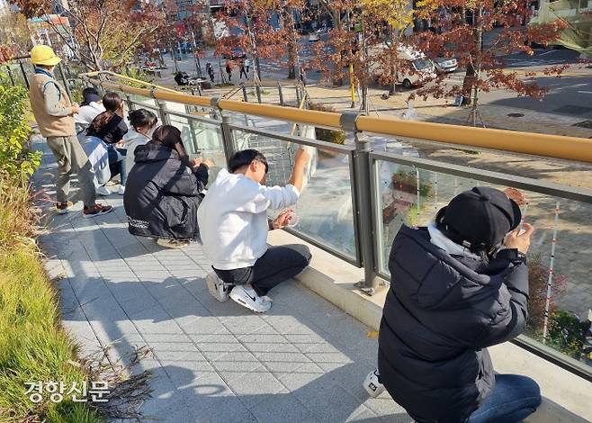 이화여대 윈도우스트라이크 모니터링팀이 지난 6일 시민들과 함께 서울 서대문구 신촌 기차역 유리 난간에 조류충돌 방지 스티커를 붙이고 있다.