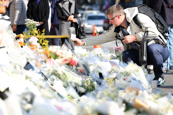 A visitor pays respect to the victims of the Itaewon tragedy at a makeshift memorial near Exit 1 of Itaewon Station on Sunday afternoon. [YONHAP]