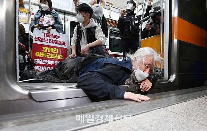 전국장애인차별철폐연대(전장연) 소속 장애인들이 출근길 지하철 탑승 시위 모습 [사진 = 이충우 기자]