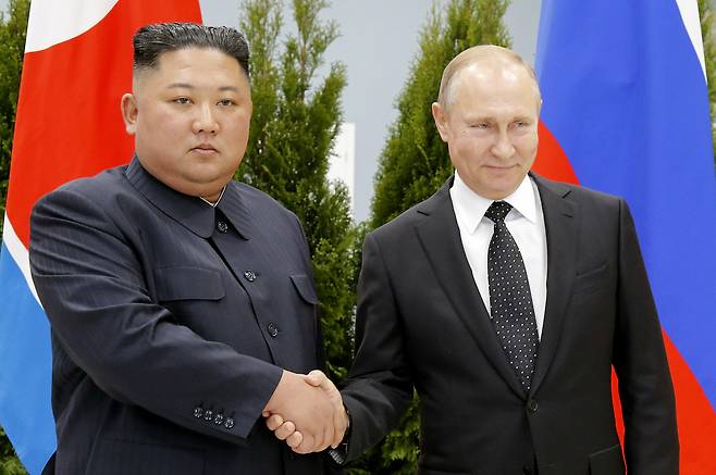 Russian President Vladimir Putin (right) and North Korea's leader Kim Jong-un shake hands during their meeting in Vladivostok, Russia on April 25, 2019. North Korea on Tuesday accused the United States of cooking up a "plot-breeding story" on its alleged arms transfer to Russia, arguing it has never sent artillery shells to Moscow.(AP-Yonhap)