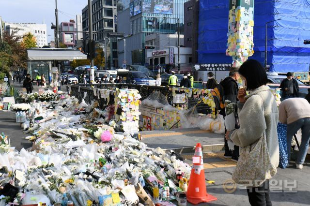 한 시민이 이태원 참사를 추모하기 위해 7일 서울 용산구 이태원역 1번출구에서 꽃을 들고 있다. 최현규 기자