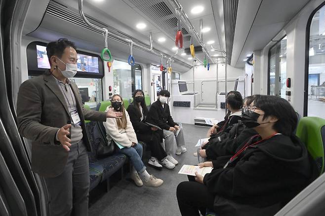 모빌리티 테마파크 부스에서 견학으로 방문한 학생들이 세종시에서 시범운행중인 양문형 전기 굴절버스 S-BRT에 대한 설명을 듣고 있다.