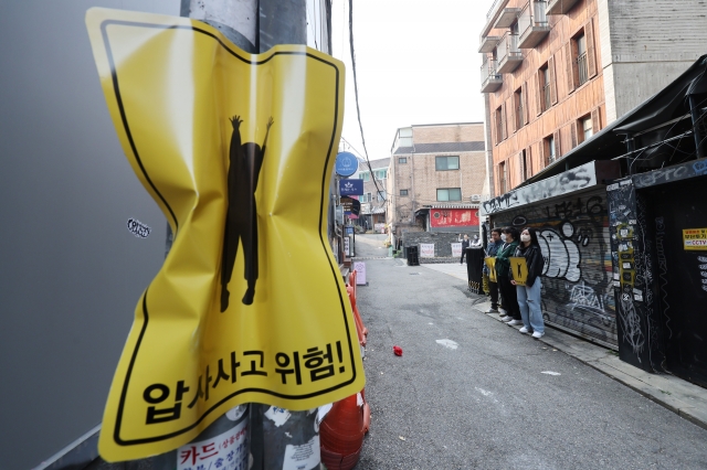 이제석 광고연구소 관계자들은 10일 오후 서울 마포구 홍익대 정문 인근 골목에 압사 사고 위험구간 표지판을 부착했다. 이제석광고연구소 제공.