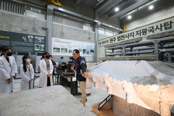 Visitors to the Cultural Heritage Conservation Science Center's opening day on Nov. 3 listen to Lee Tae-jong, a researcher working on the restoration of the funerary stupa honoring eminent Goryeo monk and State Preceptor Jigwang (984-1067). This national treasure had to be dismantled for a complete restoration in 2016. The work is nearly done, and it will soon leave the center at the end of this year. [YONHAP]