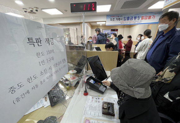 신협 연 10% 적금 등장… 온라인서 6분 만에 소진 - 금리 인상기 두 자릿수 금리가 적용되는 적금이 등장하면서 영업시간 전부터 상품 가입을 위해 줄을 서는 ‘오픈런’이 이어지고 있다. 27일 서울 관악구 관악신협에서 고객들이 연 10% 적금 특판에 가입하기 위해 상담을 받고 있다. 해당 적금의 온라인 판매 한도 350억원은 이날 오전 6시 판매 시작 6분 만에 소진됐다.연합뉴스