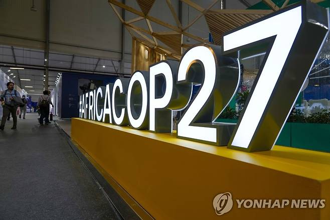 COP27 (샤름 엘 셰이크 AP=연합뉴스) 제27차 유엔기후변화협약 당사국 회의(COP27) 개막을 하루 앞둔 5일(현지시간) 사람들이 이집트 샤름 엘 셰이크 컨벤션 센터의 부스 앞을 지나가고 있다. COP27은 오는 18일까지 열리며 조 바이든 미국 대통령과 리시 수낵 영국 총리를 비롯한 80여 개국 정상과 국가 수반급 인사가 참석해 기후 위기 해법에 대해 논의할 예정이다. 2022.11.06 ddy04002@yna.co.kr