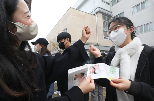 2023학년도 대학입학수학능력 시험을 하루 앞둔 16일 세종시 아름고등학교에서 열린 예비소집에서 수험생들이 담임교사로부터 수험표를 받으며 파이팅을 외치고 있다. 세종=뉴스1