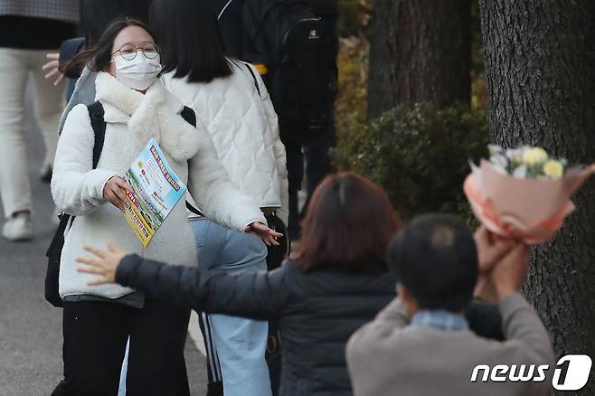 2023학년도 대학수학능력시험일인 17일 오후 대구 수성구 혜화여자고등학교 교문 앞에서 오랜 시간 꽃다발을 들고 기다리던 수험생 부모가 수능을 마치고 나오는 딸을 맞이하고 있다. 2022.11.17/뉴스1 ⓒ News1 공정식 기자