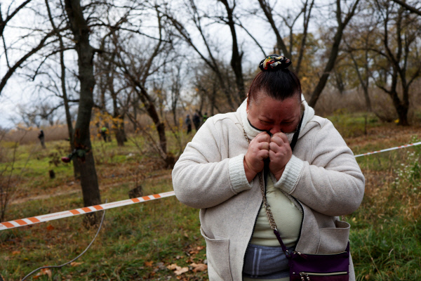 우크라이나 경찰이 16일 헤르손 전역에서 실종자를 수색하는 가운데 한 여성이 눈물을 흘리고 있다. 로이터 연합뉴스