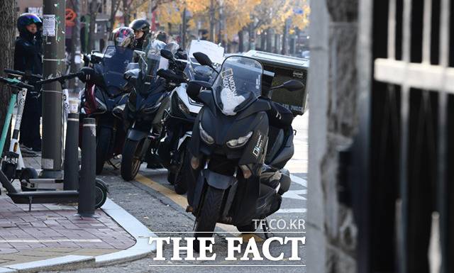 20일 오전 서울 동대문구 경희대학교에서 2023학년도 대입 수시전형 논술시험이 진행된 가운데, 퀵서비스 오토바이 기사들이 수험생을 태우기 위해 정문 앞에서 대기하고 있다.
