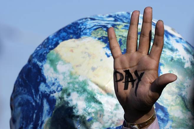 환경운동 활동가들이 기후위기를 촉발한 선진국들이 손실을 입은 개발도상국에 보상할 것을 촉구하며 지난 18일(현지시간) ‘지불’이라는 글자가 쓰인 손바닥을 펼쳐 보이고 있다. 샤름엘셰이크 | AP연합뉴스