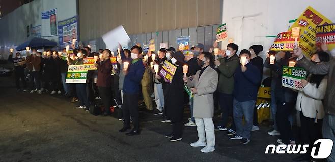 한국주식투자자연합회는 지난 13일 오후 서울 여의도 민주당사 앞에서 금융투자소득세 도입에 반대하는 촛불시위를 가졌다/사진=뉴스1 제공