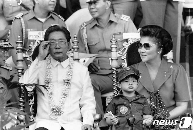 1985년 11월 페르디난드 마르코스 전 필리핀 대통령과 그의 부인 이멜다, 아들 마르코스 주니어가 대학생들의 군사훈련 모습을 지켜보고 있다. ⓒ AFP=뉴스1 ⓒ News1 강민경 기자