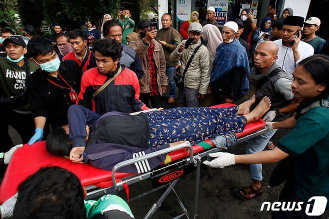 21일(현지시간) 규모 5.6의 지진이 강타한 인도네시아 치안주르에서 주민들이 부상자를 병원으로 옮기고 있다. ⓒ AFP=뉴스1 ⓒ News1 우동명 기자