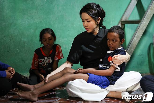 윤석열 대통령 부인 김건희 여사가 12일 캄보디아 프놈펜에서 선천성 심장질환을 앓고 있는 14세 아동의 집을 찾아 아이를 안고 있다. (대통령실 제공) 2022.11.13/뉴스1 ⓒ News1 안은나 기자