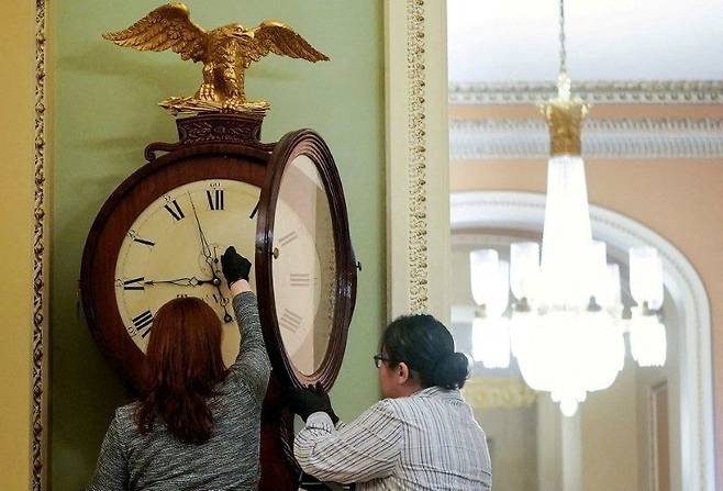 미국 오하이오주 국회의사당에서 직원들이 시계를 수리하고 있다. /연합뉴스