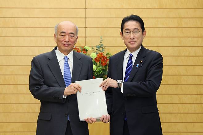 일본 정부가 구성한 전문가 회의 좌장인 사사에 겐이치로 전 외무성 사무차관이 22일 방위력 강화를 위한 최종 보고서를 기시다 후미오 일본 총리에게 전달하고 있다. 총리 관저 누리집 갈무리