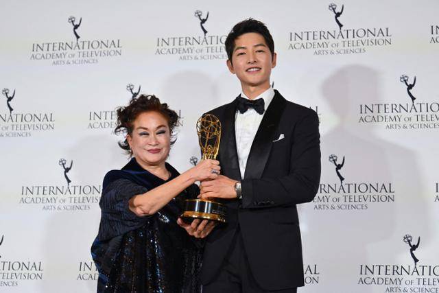 이미경(왼쪽) CJ그룹 부회장이 21일(현지시간) 미국 뉴욕 힐튼호텔에서 열린 제50회 국제 에미상 시상식에서 시상자인 배우 송중기로부터 공로상 트로피를 받은 후 함께 포즈를 취하고 있다. 뉴욕=AFP 연합뉴스
