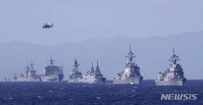 [사가미만=교도·AP/뉴시스]일본 해상자위대 구축함 아사히함(사진 오른쪽)과 다른 군함들이 지난 6일 도쿄 남쪽 사가미만에서 국제 함대 사열에 합류하고 있다. 미국, 호주, 캐나다, 인도, 뉴질랜드, 싱가포르, 한국 등 12개국에서 18척의 군함이 참가했으며, 미국과 프랑스도 검토를 위해 전투기를 파견했다. 2022.11.22.