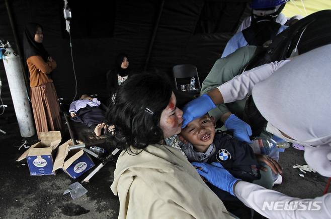 [치안주르=AP/뉴시스] 21일(현지시간) 인도네시아 서자바주 치안주르에서 규모 5.6의 지진이 발생해 부상자들이 임시 병원에서 치료받고 있다. 현지 당국은 이번 지진으로 지금까지 최소 162명이 숨졌다고 밝혔으며 사망자 수는 더 늘어날 것으로 보인다. 2022.11.22.