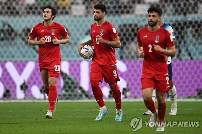 '이란 만회골' 메디 타레미(가운데)가 동료와 묵묵히 센터서클로 돌아오는 모습 [AFP 연합뉴스 자료사진. 재판매 및 DB 금지]