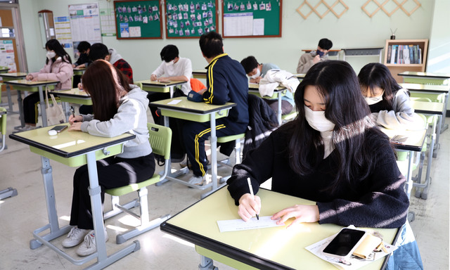 지난 18일 오전 서울 영등포구 선유고등학교에서 고3 학생들이 전날 치른 2023학년도 대학수학능력시험 가채점표를 작성하고 있다. 연합뉴스