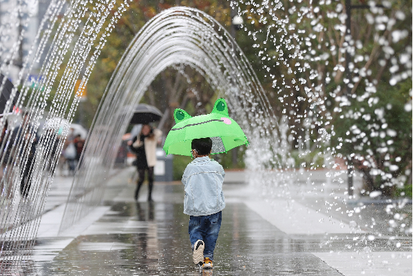 전국 곳곳에 비 소식이 있는 9일 오전 서울 광화문광장을 찾은 한 어린이가 우산을 쓴 채 터널분수를 지나고 있다.[사진제공=연합뉴스]