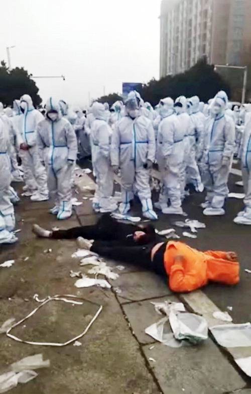 23일 중국 정저우시 폭스콘 공장의 방역요원들이 폭행당해 쓰러진 것으로 추정된 한 직원을 내려다보고 있다.  【트위터 캡처】
