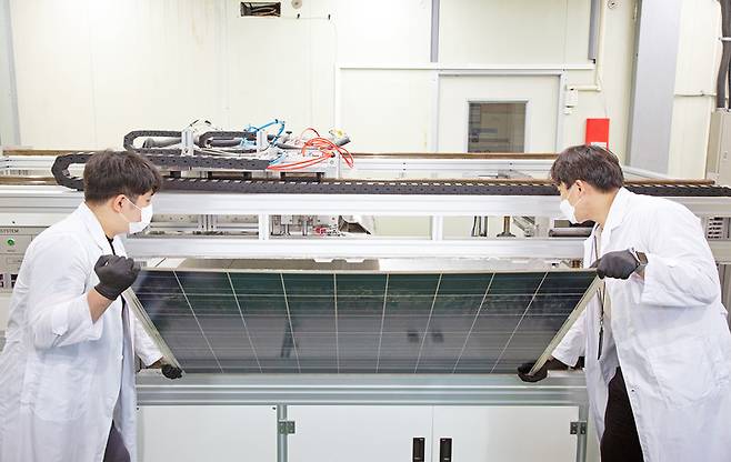 [대전=뉴시스] 에너지연구원 연구원들이 유리를 분리·회수키 위해 태양광 폐패널을 개발한 장치에 넣고 있는 모습. *재판매 및 DB 금지