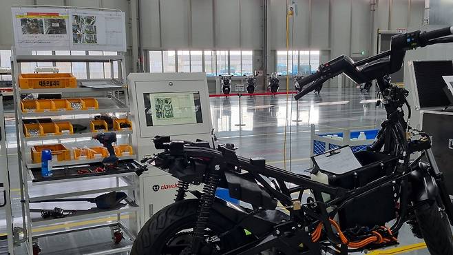 23일 준공된 대동모빌리티 S-팩토리. 전기스쿠터 조립장에 컨베이어 벨트 대신 무인로봇을 탄 전기스쿠터와 공정 내용이 적힌 키오스크가 보인다. /대구=이은영 기자
