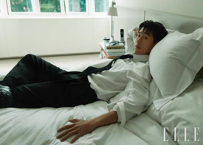 화이트 클래식 핏 셔츠와 블랙 울 타이, 블랙 울 트라우저, 스니커즈는 모두 Burberry.