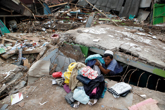 24일(현지시간) 인도네시아 서자바주 시안주르에서 주민들이 파괴된 집에서 물건들을 건져내고 있다. 로이터연합뉴스